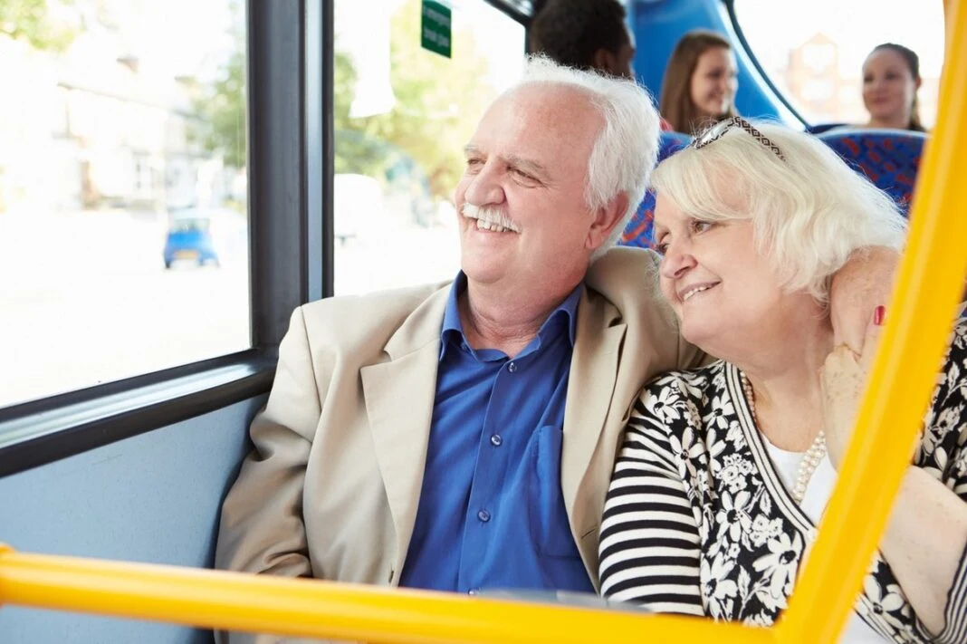 Pareja de adultos mayores viajando en transporte público